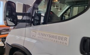 Applikation der neuen JEWE-Fahrzeugbeschriftung an der Fahrertüre.